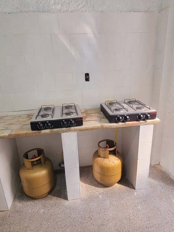 Detalle de la cocina: los dos anafes sobre la losa de piedra apoyada en pilares de bloque azulejado.
